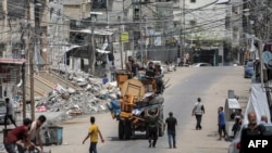 Men ride in the back of a truck loaded with furniture and other items as they flee bound for Khan Yunis, in Rafah in the southern Gaza Strip on May 11, 2024.