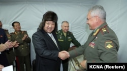 Pemimpin Korea Utara Kim Jong Un menjabat tangan Menteri Pertahanan Rusia Sergei Shoigu ketika berkunjung ke Vladivostok, Rusia, pada 16 September 2023. (Foto: KCNA via Reuters)