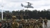 FILE - Tentara Filipina dan Australia berbaris dalam formasi, sementara helikopter marinir AS V-22 Osprey melayang di atas selama latihan militer Alon, di pangkalan angkatan laut kota San Antonio, provinsi Zambales, utara Manila, 25 Agustus 2023. (TED ALJIBE / AFP)