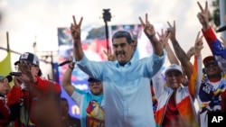 FILE - Venezuelan President Nicolas Maduro flashes victory hand signs at supporters during a pro-government rally, in Caracas, Venezuela, Aug. 17, 2024. 