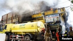 Somali police stand guard after an explosion at a shopping mall area that caused fire at the Bakara market in Mogadishu, March 10, 2024.