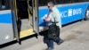 FILE - A woman boards a bus in Kansas City, Mo., March 3, 2021.