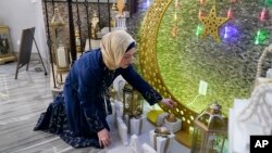 FILE - Suzanne Jaber of The Eid Shop looks at some of her company's Ramadan decorations she created, in Dearborn Heights, Michigan, March 27, 2023. Ramadan starts Sunday or Monday, depending on moon sightings.