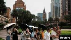Visitors take pictures in front of a replica of Big Ben at the Londoner Macao casino resort, which is operated by Sands China, during Labor Day holiday in Macao, China, April 30, 2023. 