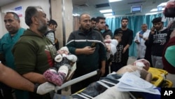 Palestinian children wounded in the Israeli bombardment of the Gaza Strip are brought to the hospital in Deir al Balah, Gaza Strip, Dec. 11, 2023. 