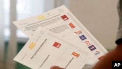 A man casts his ballots during the parliamentary election and the presidential runoff at a polling station in Skopje, North Macedonia, May 8, 2024.