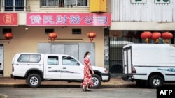 FILE - A woman walks in Cyrildene, also known as Johannesburg's China Town, South Africa, Feb. 07, 2020. Under apartheid, the country's Chinese were among minorities not allowed to vote. That changed on Freedom Day 29 years ago.