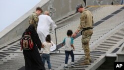 Tentara AS mengawal warga negara Amerika ke kapal Angkatan Laut AS di Port Sudan, Minggu, 30 April 2023. (AP/Smowal Abdalla)