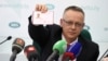Tomasz Szmydt, a Polish judge who requested political asylum in Belarus, shows his ID document during a press conference in Minsk, Belarus, May 6, 2024. (BelTA/Maxim Guchek/Handout via Reuters)