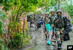 Indian paramilitary soldiers arrive to guard a venue for the distribution of Electronic Voting Machines and other election material in Srinagar, Indian-controlled Kashmir, May 12, 2024.