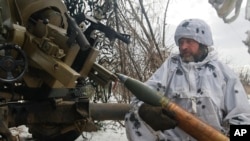 A Ukrainian soldier prepares to fire artillery at Russian positions near Bakhmut, Donetsk region, Ukraine, Feb. 15, 2023. 