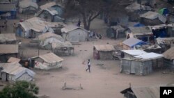 FILE - People stand by their houses in Juba, South Sudan, on Feb. 5, 2023. South Sudan’s government is closing down all schools starting Monday as the country prepares for a wave of extreme heat expected to last two weeks. 