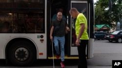 Accompanied by trainer Vasyl Hoshovskyi, Ivan Soroka, a former Ukrainian soldier blinded in the war, gets off a bus in Rivne, Ukraine,