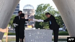 El alcalde de Hiroshima, Kazumi Matsui, y los representantes de las familias en duelo consagran una lista de las víctimas de la bomba atómica en el cenotafio durante una ceremonia en el Parque Conmemorativo de la Paz en Hiroshima, el 6 de agosto de 2023.