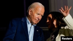 Vice President Kamala Harris speaks with President Joe Biden on a White House balcony during an Independence Day celebration in Washington, July 4, 2024. 