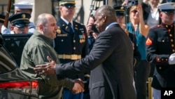 Defense Secretary Lloyd Austin, right, greets Ukraine's Defense Minister Rustem Umerov during an arrival ceremony at the Pentagon, near Washington, July 2, 2024.