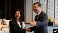 Shanghai Party Secretary Chen Jining gestures as he shakes hands with U.S. Commerce Secretary Gina Raimondo before a meeting in Shanghai, China, on Aug. 30, 2023.