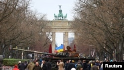 The remains of a destroyed Russian T-72 tank, secured from the Ukrainian village of Dmytrivka, outside Kyiv are on display near the the Brandenburg Gate during an event to mark the one-year anniversary of the Russian invasion of Ukraine, in Berlin, Germany, Feb. 24, 2023. 