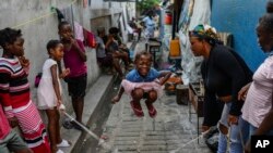 FILE - A girl jumps rope at a school housing residents displaced by gang violence in Port-au-Prince, Haiti, May 15, 2024.