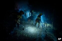 Emergency crews and firefighters are working to extinguish the fire advancing through the forest near the town of El Rosario in Tenerife, Canary Islands, Spain, Aug. 18, 2023.
