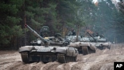 FILE - Ukrainian soldiers on captured Russian tanks hold military training close to the Ukraine-Belarus border near Chernihiv, Ukraine, Oct. 28, 2022. 