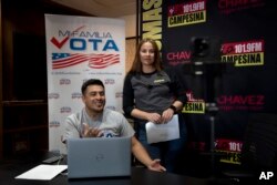 Staff members Michael Ruiz, left, and Marisol Moraga participate in a phone bank event at Radio Campesina, a Spanish-language network in Phoenix, March 20, 2024.