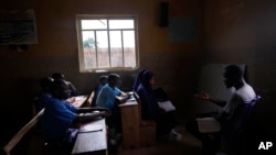 Students of Excellent Moral School attend a lesson in a window-lit classroom in Ibadan, Nigeria, Tuesday, May 28, 2024. (AP Photo/Sunday Alamba)