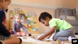 FILE - Elijah Rollings, 2, plays with a train set at Bumble Art Studio daycare center in Astoria, Ore., Friday, Sept. 2, 2022. (AP Photo/Craig Mitchelldyer)