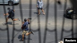 ရန်ကုန်မြို့ စစ်အာဏာသိမ်းဆန့်ကျင် ဆန္ဒပြပွဲတခုအတွင်း အပြေးအလွှားသတင်းယူနေတဲ့ သတင်းထောက်တဦးကို တွေ့ရစဉ် (ဖေဖော်ဝါရီ ၂၇၊ ၂၀၂၁)