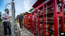 P V R Murthy, center, a general manager at Oil India Limited, shows a part of a hydrogen plant in Jorhat, India, on Aug. 17, 2023. Green hydrogen is touted as a clean energy solution to take the carbon out of high-emitting sectors like transport and industrial manufacturing.