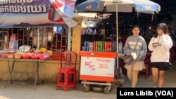 រូបឯកសារ៖ សិស្សសាលាពីរនាក់ ដើរចេញពីអាហារដ្ឋានក្នុងវិទ្យាល័យបាក់ទូក ក្បែរកន្លែងលក់នំចំណី ក្នុងរាជធានីភ្នំពេញ កាលពីថ្ងៃទី២១ ខែកុម្ភៈ ឆ្នាំ២០២៣។ (លាស់ លីបលីប/វីអូអេ)