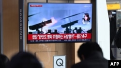 People watch a television screen showing a news broadcast with file footage of North Korea's artillery firing, at a railway station in Seoul, South Korea, on Jan. 5, 2024. 
