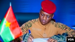 Le Capitaine Ibrahim Traoré signant la charte prolongeant la Transition de cinq ans, Ouagadougou, le 27 mai 2024 (VOA/Lamine Traoré)