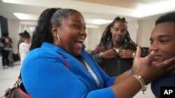 Valerie Laveus greets her nephew Tristan-Ryan Malherbe Daniel, as he and his dad, Reginald Malherbe Daniel, rear, arrive for the first time to the United States from Haiti at Fort Lauderdale-Hollywood International Airport, in Fort Lauderdale, Fla., Aug. 9, 2023.