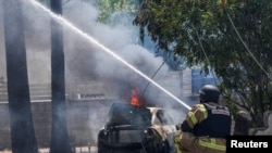 Seorang petugas damkar memadamkan api di lokasi yang terkena roket yang diluncurkan dari Lebanon di tengah meningkatkan kekerasan antara kelompok Hizbullah dan pasukan Israel di Kiryat Shmona, utara Israel, Minggu, 5 Mei 2024. (Foto: Ayal Margolin/Reuters)