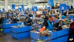 Cashiers process purchases at a Walmart Supercenter in North Bergen, New Jersey, Feb. 9, 2023.
