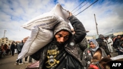 Displaced Palestinians receive food aid at an UNRWA distribution center in Rafah, in the southern Gaza Strip, Jan. 28, 2024.