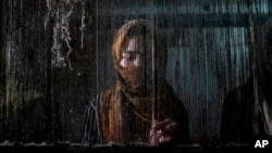 A woman weaves a traditional Afghan carpet at a factory in Kabul, Afghanistan, March 6, 2023.