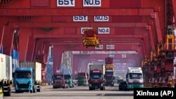 集装箱船正在中国山东省青岛港进行卸载。（2024年2月11日）