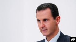 FILE - Syria's Bashar al-Assad speaks in Damascus, Nov. 9, 2019. A Paris court on May 24, 2024, found three Syrians guilty of war crimes and crimes against humanity in the deaths of two French nationals. Assad's regime has long been accused of committing atrocities. (SANA via AP)