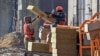 FILE - Laborers work on a construction site in Moscow, March 12, 2021. Thousands of Uzbeks working in Russia now are considering returning home to help with the construction of the "New Tashkent" development projects. 