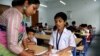 An instructor helps a student at an English modernized madrasa in West Bengal, India, April 2, 2024. (Shaikh Azizur Rahman/VOA)