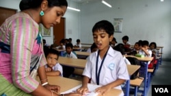 An instructor helps a student at an English modernized madrasa in West Bengal, India, April 2, 2024. (Shaikh Azizur Rahman/VOA)