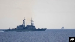 FILE - In this photo released by the Taiwan Ministry of National Defense, Taiwan guided missile destroyer Ma Kong DDG1805, left, monitors Chinese guided missile destroyer Xi'an DDG15, right, near Taiwan on May 23, 2024. 