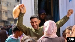 A Palestinian man reacts after buying subsidized bread outside a bakery in Gaza City on April 14, 2024.