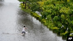 A man runs across Bayshore Boulevard, which was flooded from the storm surge associated with Hurricane Idalia on Aug. 30, 2023, in Tampa, Florida. Idalia made landfall earlier this morning along the Big Bend of the state.