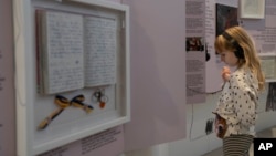 A child listens to audio with a video at the War Diaries exhibition at Amsterdam city hall, Netherlands, Aug. 17, 2023.