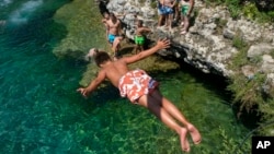 A boy dives into the Cijevna river near Montenegro's capital of Podgorica, as temperatures soared to 36 degrees Celsius on July 11, 2024.