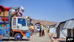 FILE - Pengungsi Afghanistan berjalan di pusat pendaftaran setibanya dari Pakistan di distrik Takhta Pul, provinsi Kandahar, 22 Mei 2024. (Sanaullah SEIAM / AFP)