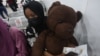 A Nigerian student fleeing Sudan clutches a stuffed bear while at the Nnamdi Azikwe International Airport in Abuja, Nigeria, May 4, 2023.